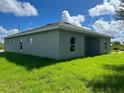 Rear view of a new light grey house with green grass at 12577 Willmington Blvd, Port Charlotte, FL 33981