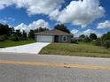 New single-Gathering home with a white garage door and grassy yard at 12577 Willmington Blvd, Port Charlotte, FL 33981