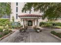 Condo building entrance with covered walkway, benches, and landscaping at 25188 Marion Ave # A103, Punta Gorda, FL 33950