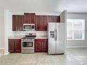 Kitchen with stainless steel appliances and dark wood cabinets at 423 Durham Shore Ct, Apollo Beach, FL 33572