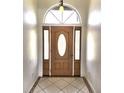 Elegant entryway with arched window and wood door at 1847 Wheeling Ave, North Port, FL 34288