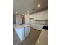 Modern kitchen with granite countertops, stainless steel appliances, and a large island at 9613 Vibrant Lane, Venice, FL 34292