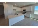 Bright kitchen featuring white cabinets, stainless steel appliances, and a center island at 9613 Vibrant Lane, Venice, FL 34292