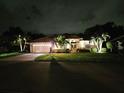 Attractive home exterior with landscape lighting at night at 4450 Golden Lake Dr, Sarasota, FL 34233