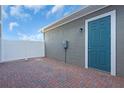 Cozy outdoor brick patio with blue back door and white fence, perfect for relaxation and entertainment at 17314 Alderwood Ln, Punta Gorda, FL 33982