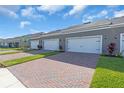 A row of garages with brick driveways and well-maintained grassy areas at 17326 Alderwood Ln, Punta Gorda, FL 33982