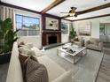 Living room with a fireplace, hardwood floors, and large windows at 1427 E Gate Dr, Venice, FL 34285