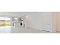 Open living area with gray tile floors and access to the kitchen and patio at 17347 Peregrine Way, Punta Gorda, FL 33982