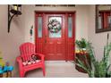 Red front door with a wreath and a red chair on the porch at 6043 Anvil Ave, Sarasota, FL 34243