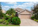 Tan house with a three-car garage and lush landscaping at 6043 Anvil Ave, Sarasota, FL 34243
