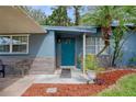 Inviting home exterior with teal front door and landscaping at 7329 Royal Palm Dr, New Port Richey, FL 34652