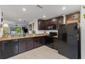 Modern kitchen with granite countertops and dark wood cabinets at 1276 Banter Cir, North Port, FL 34288