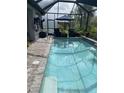Relaxing screened-in pool with a waterfall feature and comfortable seating at 2633 Daisy Dr, North Port, FL 34289