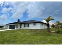 White brick home with black metal roof and landscaping at 1359 Cambridge Dr, Venice, FL 34293