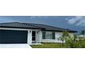 White brick home with a black metal roof and garage at 1359 Cambridge Dr, Venice, FL 34293