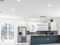 Bright, modern kitchen featuring stainless steel appliances, a breakfast bar, and sleek white cabinetry at 5316 Altoona St, Sarasota, FL 34232