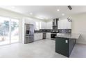 Modern kitchen features stainless steel appliances, gray backsplash, granite countertops, and an island at 5316 Altoona St, Sarasota, FL 34232