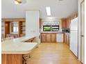 Bright eat-in kitchen featuring an island counter with seating, built-in shelving, and white appliances at 35935 Tanda Cir, Zephyrhills, FL 33541