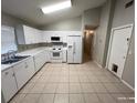 Efficient kitchen with white cabinets and tile flooring at 6115 Sand Key Ln, Wesley Chapel, FL 33545