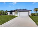 One story home with a two car garage and landscaped lawn at 3841 San Pedro Ave, North Port, FL 34288