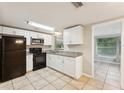 Bright kitchen with white cabinets, granite countertops, and black appliances at 10226 Willow Dr, Port Richey, FL 34668