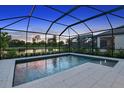 Enclosed pool and patio area at sunset, overlooking a lake at 15157 Shady Palms Ln, Nokomis, FL 34275