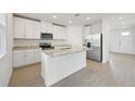 Modern kitchen with white cabinets, granite counters, and island at 168 Lazy Shore Dr, Nokomis, FL 34275