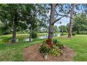 Landscaped backyard with pond view, lush foliage, and mature trees at 7319 Eleanor Cir, Sarasota, FL 34243