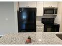 Modern kitchen with granite countertop and black appliances at 624 Golden Raintree Pl # 624, Brandon, FL 33510