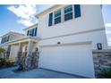 Two-story house with white exterior and stone accents at 8493 Hardy Bay Loop, Wesley Chapel, FL 33545