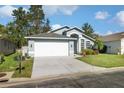 Beautiful blue home featuring an attached two-car garage and a well maintained front yard at 7940 Fashion Loop, New Port Richey, FL 34654