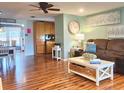 Bright living room with hardwood floors, brown sectional sofa, and a coffee table at 751 Nantucket Rd, Venice, FL 34293