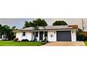 House exterior with solar panels, gray garage door and landscaped front yard at 751 Nantucket Rd, Venice, FL 34293