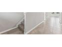 Hallway with neutral tile flooring and stairway with carpeted steps at 3910 Radiant Mountain Dr, Plant City, FL 33565