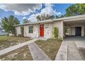 Front view of a remodeled home with red door and carport at 6445 Skyline Ct, Spring Hill, FL 34606