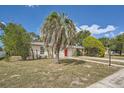 Front view of a newly remodeled home with a red door and a palm tree at 6445 Skyline Ct, Spring Hill, FL 34606