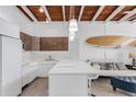 Bright kitchen featuring white countertops, breakfast bar, and modern cabinetry at 1129 Seaside Dr # 7, Sarasota, FL 34242
