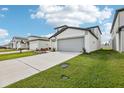 Two-story house with gray siding, attached garage, and landscaped lawn at 3905 Radiant Mountain Dr, Plant City, FL 33565