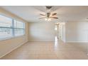 Bright living room with tile floors and ceiling fan at 11715 Enterprise Dr, Port Richey, FL 34668