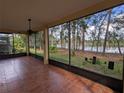 Relaxing screened-in lanai with tile flooring, ceiling fan and serene views of the lush backyard and pond at 23713 Acorn Hill Dr, Lutz, FL 33559