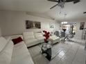 Spacious living room featuring a white sectional sofa and glass coffee table at 20102 Lorenzo Ave, Port Charlotte, FL 33952