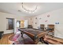 Spacious game room featuring a pool table, accent wall decor, hardwood floors, and a doorway to another room at 11909 Mandevilla Ct, Tampa, FL 33626