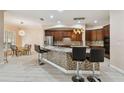 Modern kitchen featuring a center island with barstool seating, stainless steel appliances, and modern lighting fixtures at 11909 Mandevilla Ct, Tampa, FL 33626