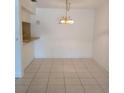 Bright dining area with tile flooring, an elegant chandelier, and a breakfast bar for casual meals at 642 Bird Bay E Dr # 205, Venice, FL 34285