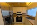 Compact kitchen with stainless steel appliances, bright cabinetry, and light countertops for a clean look at 642 Bird Bay E Dr # 205, Venice, FL 34285