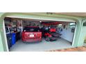 Well-organized garage featuring a car, golf cart, and custom flooring at 906 Bluewater Dr, Sun City Center, FL 33573