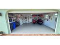 Spacious and organized garage featuring motorbikes, ample storage and work area, and custom flooring at 906 Bluewater Dr, Sun City Center, FL 33573