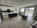 Open kitchen with white cabinets, island, and stainless steel appliances at 10922 Brightleaf Ct, Riverview, FL 33569