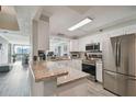 Bright kitchen featuring stainless steel appliances, white cabinets, and a granite countertop bar at 2413 Bayshore Blvd # 1404, Tampa, FL 33629