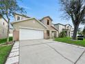 Two-story house with a two-car garage, and a well-manicured lawn at 7116 Early Gold Ln, Riverview, FL 33578